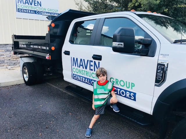 little boy next to Maven Restoration truck